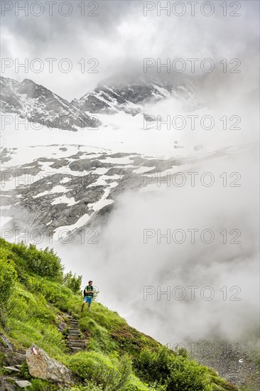 Mountaineers on a hiking trail, Schlegeiskees glacier in the background, cloudy and atmospheric mountain landscape, ascent to Furtschaglhaus, Berliner Hoehenweg, Zillertal, Tyrol, Austria, Europe