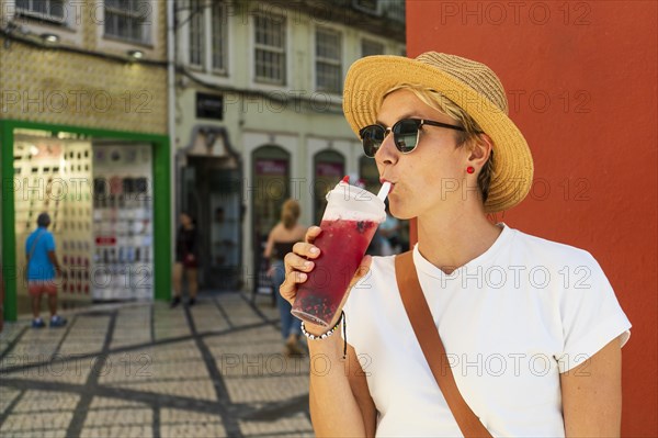 Happy woman drinking tea in beautiful town, coimbra