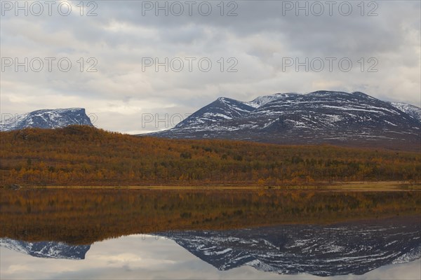 Autumn atmosphere in Abisko National Park at Lake Vuolep Njakajaure. Laporten reflected in the lake