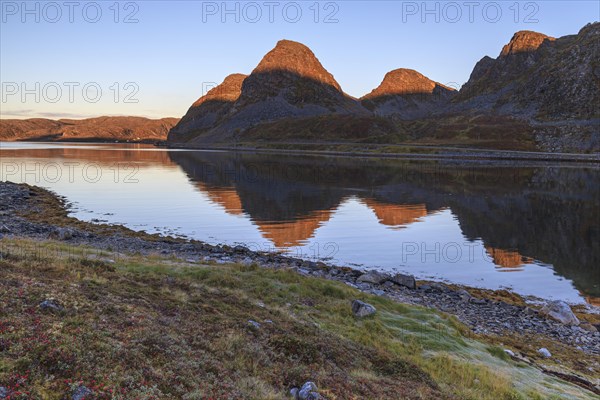 Reflection of Bergen in the fjord at morning light, autumn, Nordkinn Peninsula, Finnmark, Norway, Europe