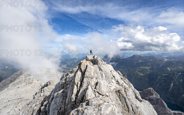 Mountaineer on the rocky summit of the Watzmann Mittelspitze, Watzmann crossing, view of mountain panorama, Berchtesgaden National Park, Berchtesgaden Alps, Bavaria, Germany, Europe