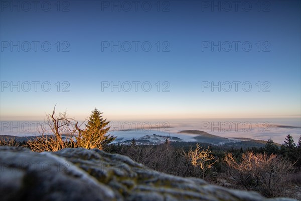 Landscape on the Grosser Feldberg, Taunus volcanic region. A cloudy, sunny winter day, meadows, hills, snow and forests with a view of the winter sunset. Hesse, Germany, Europe