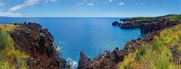 Panoramic view of a rugged coastal landscape with volcanic cliffs and sweeping sea views, lava rocks coastal hiking trail Ponta da Iiha, Manhenha, west coast, Pico, Azores