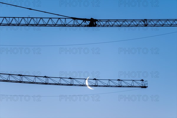 Crescent moon, in front of a construction crane, Germany, Europe