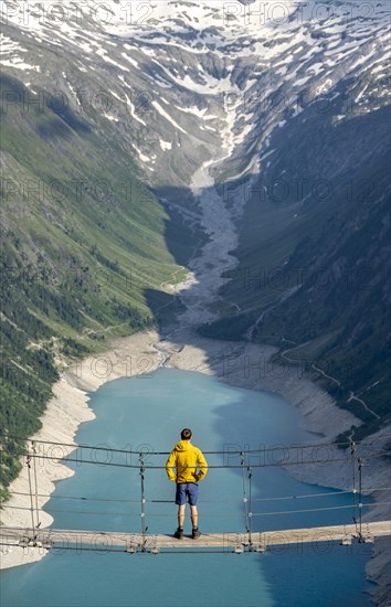 Mountaineers on a suspension bridge, picturesque mountain landscape near the Olpererhuette, view of turquoise-blue lake Schlegeisspeicher, Berliner Hoehenweg, Zillertal Alps, Tyrol, Austria, Europe