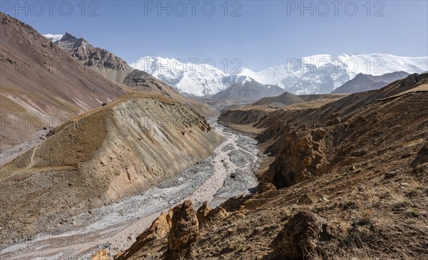 Achik Tash river, Achik Tash valley with rock formations, behind glaciated and snow-covered mountain peak Pik Lenin and Pik of the XIX Party Congress of the CPSU, Trans Alay Mountains, Pamir Mountains, Osh Province, Kyrgyzstan, Asia