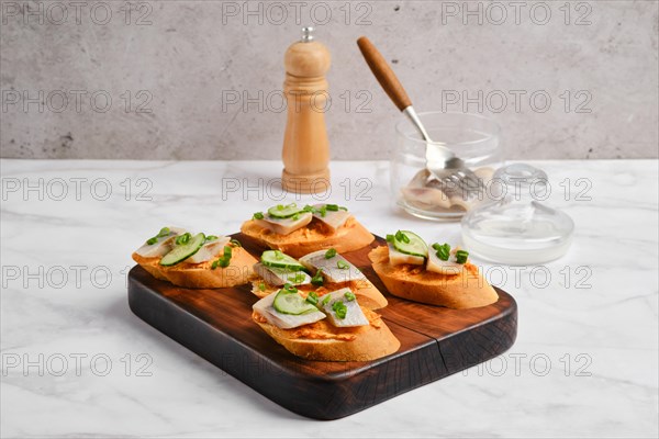 Sandwiches with salted Clupeidae on a wooden serving board