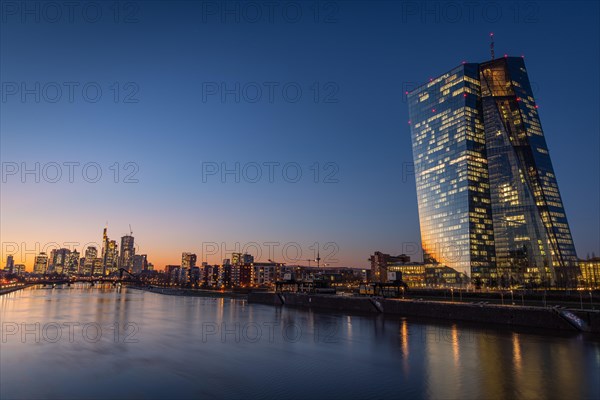 The lights of the European Central Bank (ECB) and the Frankfurt banking skyline glow in the evening, Frankfurt am Main, Hesse, Germany, Europe