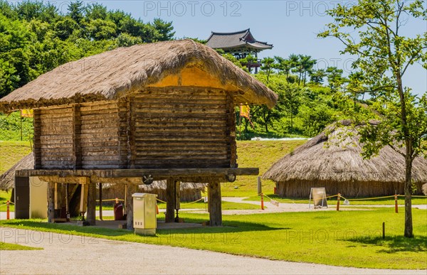 Buyeo, South Korea, July 7, 2018:Large log building with straw thatch roof elevated off ground in traditional Korean village in public park at at Neungsa Baekje Temple. For editorial use only, Asia