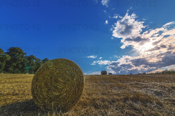 Close-up of a bale of straw in a field with impressive sky and sunbeams, Wuppertal Vohwinkel, North Rhine-Westphalia, Germany, Europe
