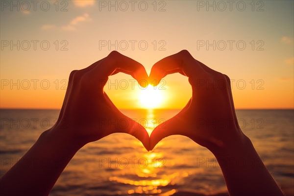 Two hands forming a heart shape, silhouetted against a breathtaking ocean sunset. Love and warmth on Valentine's Day or any romantic occasion, AI generated