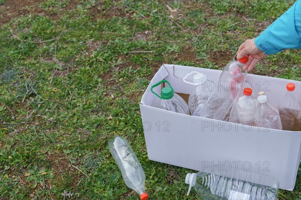 Woman collecting empty plastic bottles in the field to recycle, concept of ecology and respect for the environment