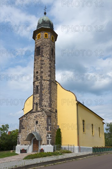 Stone church tower architecture under a cloudy sky next to a pavement, St. Nicholas Church, Gyoengyoessolymos, Gyoengyoes Matra, Heves, Northern Hungary, Hungary, Europe