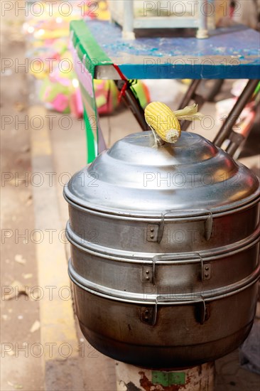 Vertical view of a metal steamer for cooking whole corn cob at the sidewalk, a popular khmer streetfood in Kampot, Cambodia, Asia