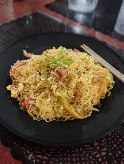 Close up to a plate of pancit bihon or Filipino stir-fried rice noodles, authentic local traditional dish from Philippines. Dipolog, Philippines, Asia