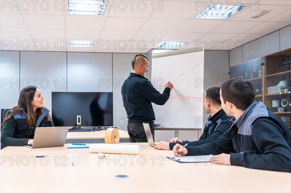 Engineer using a board during a meeting in a factory meeting room