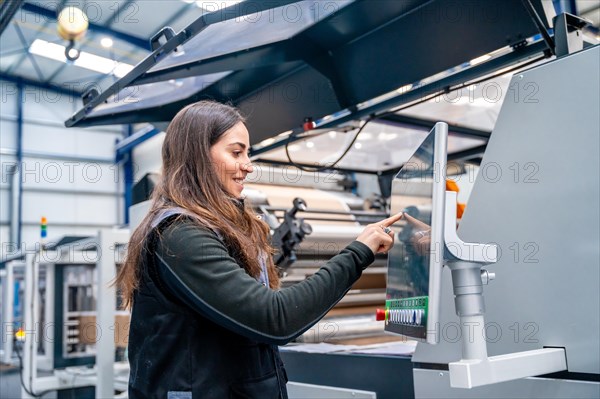 Female worker using a cnc machine to control an industrial crane