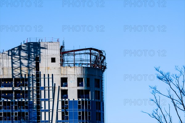 Yeoso, South Korea: December 25, 2017: Top of a building under construction with tree branches in foreground