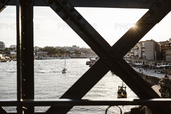 Sunset view of riverside in Porto with famous iron bridge in the front, north Portugal