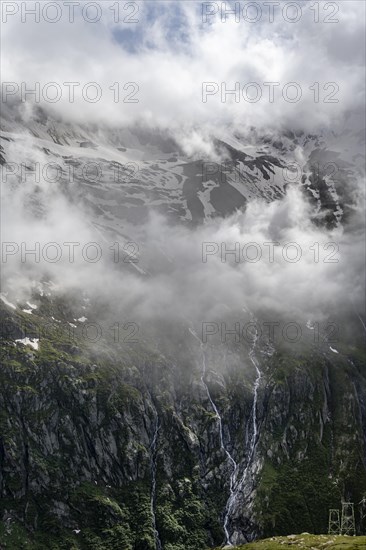 Snow-covered cloudy mountains with summit Hochsteller, mountain streams as waterfalls on a mountainside, Furtschaglhaus, Berliner Hoehenweg, Zillertal, Tyrol, Austria, Europe