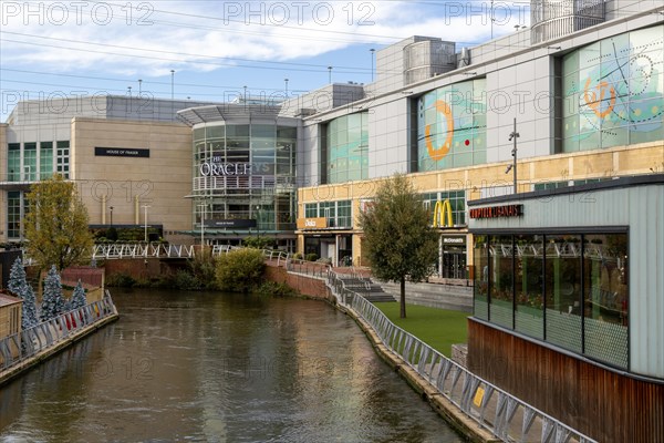 River Kennet flowing past The Oracle shopping centre in town centre, Reading, Berkshire, England, UK