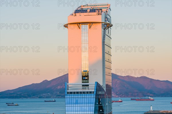 Yeoso, South Korea: December 25, 2017: Top of the MVL hotel with mountains and the harbor full of barges in the background