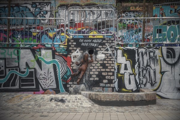 Sculpture of a person next to a fountain, surrounded by colourful graffiti, Wuppertal Elberfeld, North Rhine-Westphalia, Germany, Europe