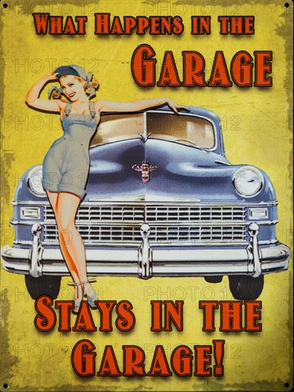 Old enamel sign 'What happens in the garage stays in the garage' woman posing by car