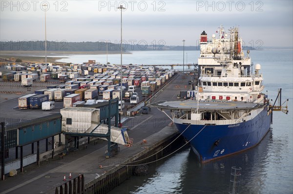 Ships and parked HGVs on quayside at the port of Harwich, Essex, England, UK, foreground Horizon Geobase North Sea supply ship