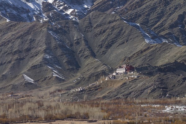 Matho Gompa, the Buddhist monastery of Central Ladakh, seen in winter, from the Thikse Monastery located on the opposite side of the Indus Valley. Mountains behind the monastery, with clearly visible strata, the rock layers, belong to the Zanskar Range of the Himalayas. Many inhabitants of Ladakh follow the Tibetan Buddhism, and this Indian region is often called Little Tibet. District Leh, Union Territory of Ladakh, India, Asia