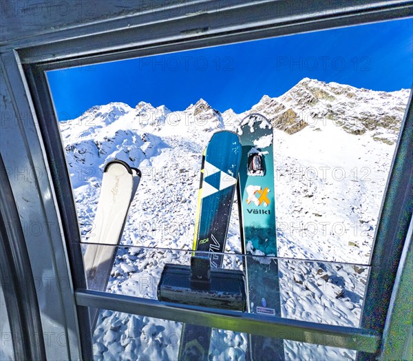 View through a gondola window of the Schwarze Schneid cable car onto skis and snow-covered mountains, Rettenbachferner, Soelden, Tyrol