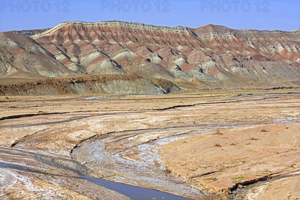 Semi-arid Azerbaijan shrub desert landscape showing mountain with sediment layers and riverbed, East Azerbaijan Province, Iran, Asia