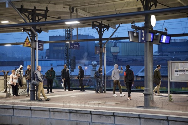 People on the platform early in the morning in front of the stainless steel plant, main railway station, Witten, North Rhine-Westphalia, Germany, Europe