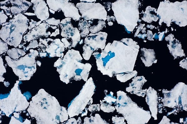 Aerial view over sea ice, drift ice, ice floes with melt ponds containing freshwater in the Arctic Ocean, Nordaustlandet, Svalbard, Spitsbergen