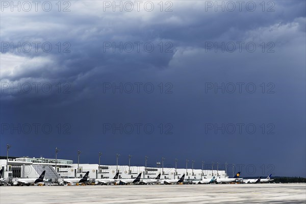 Overview Lufthansa Airlines, Star Alliance, Air Dolomiti, United Airlines aircraft at check-in position at Terminal 2 during approaching thunderstorm with rain and thunderclouds, Munich Airport, Upper Bavaria, Bavaria, Germany, Europe