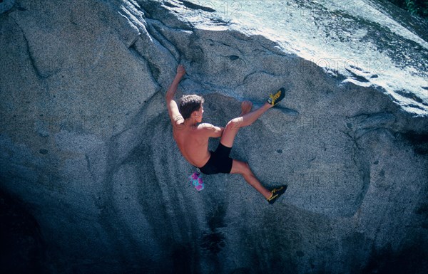 Young man with climbing shoes, chalk bag, bouldering in Yosemite Valley, California, USA, freeclimbing, North America