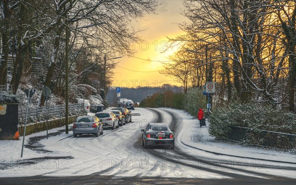 Cars driving carefully on a snow-covered road at dusk, Wuppertal Vohwinkel, North Rhine-Westphalia, Germany, Europe