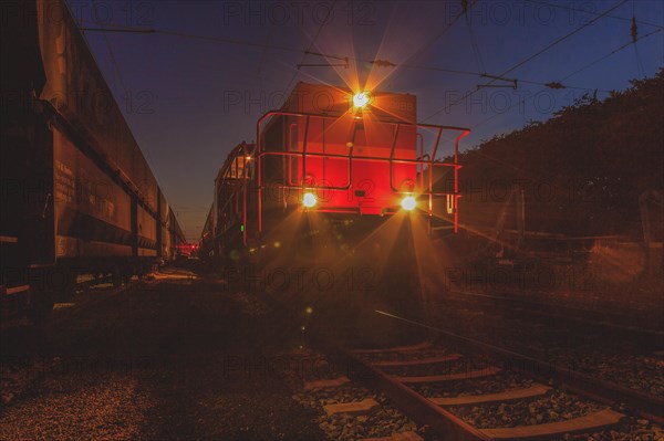Locomotive illuminates the tracks at night with headlights, Lower Rhine, North Rhine-Westphalia, Germany, Europe