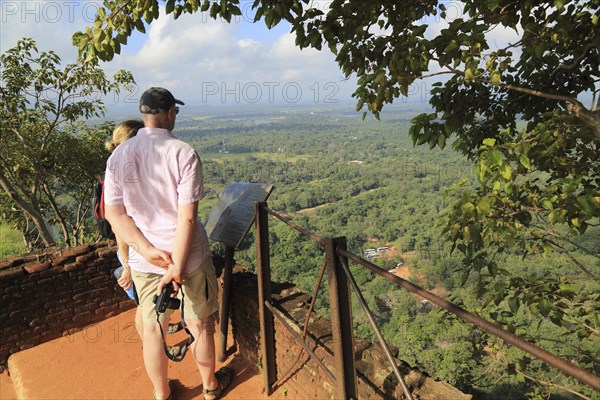 Two people looking down at the water gardens from rock palace fort, Sigiriya, Central Province, Sri Lanka, Asia