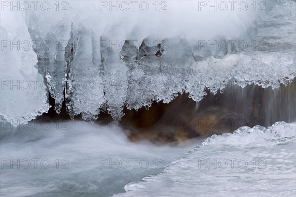 Ice formation along mountain stream in the snow in winter in the Gran Paradiso National Park, Valle d'Aosta, Italy, Europe