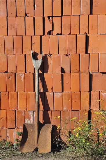 Shovel and pile of stacked red bricks at brickworks, Boom, Belgium, Europe