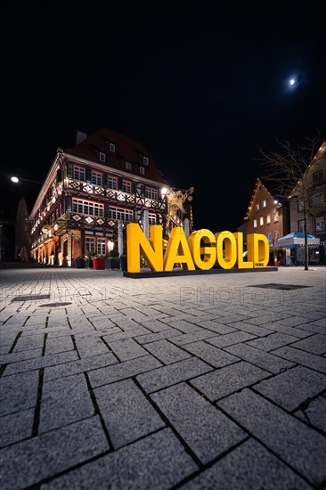 Moon over the square with half-timbered houses and 'NAGOLD' lettering at night, Nagold, Black Forest, Germany, Europe