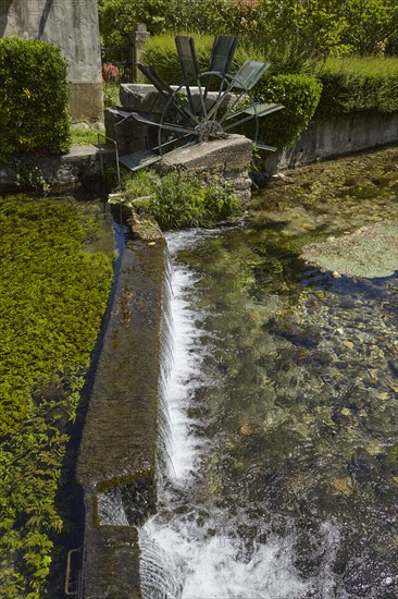 Weir with water mill wheel on a small canal in Goudargues, Departement Gard, Occitanie region, France, Europe