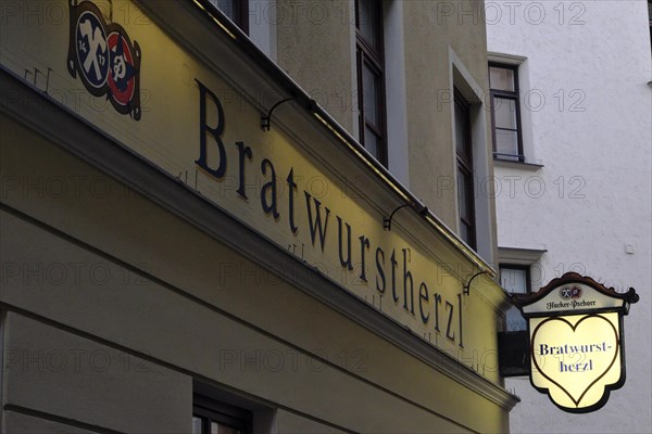 Illuminated sign of the traditional restaurant Bratwurstherzl at Viktualienmarkt, Munich, Bavaria, Germany, Europe