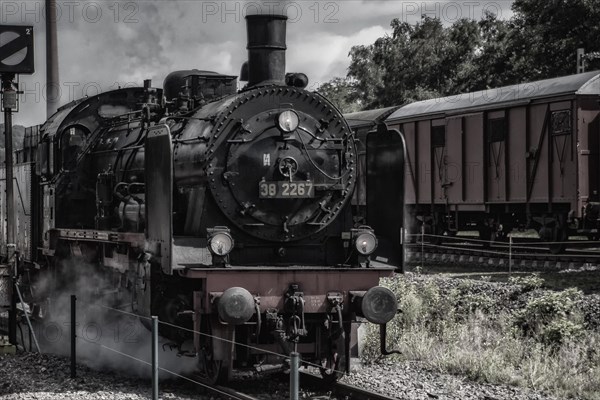 Black steam locomotive emitting smoke and waiting on the track, Dahlhausen railway depot, Lost Place, Dahlhausen, Bochum, North Rhine-Westphalia, Germany, Europe