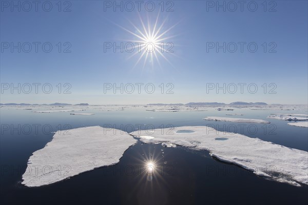 Midnight sun over the Arctic Ocean with drifting ice floes, north of the Arctic Circle at Nordaustlandet, Svalbard, Spitsbergen, Norway, Europe