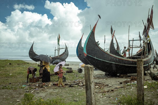 Fishing boats on the beach during a monsoon shower, Cox's Bazar, Bangladesh, Asia