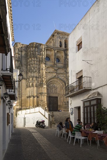 Narrow street cafe and church of Santa Maria de la Asuncion, Arcos de la Frontera, Cadiz province, Spain, Europe