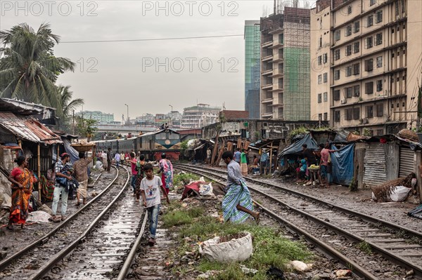 A train passes through an informal settlement built close to a railway line, Tejgaon Slum, Area, Dhaka, Bangladesh, Asia