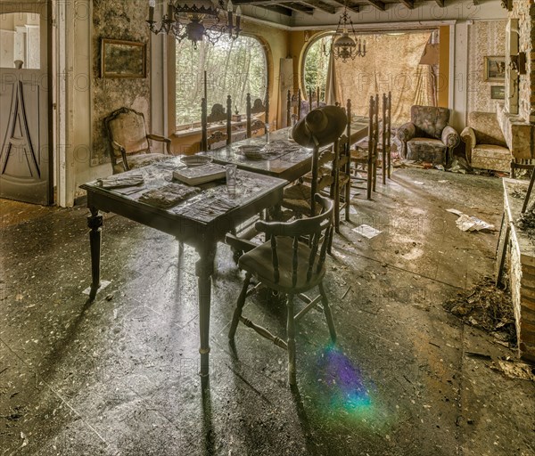Sunlight dances on the table of an abandoned, dust-covered dining room, Maison Limmi, Lost Place, Kalken, Laarne, Province of East Flanders, Belgium, Europe